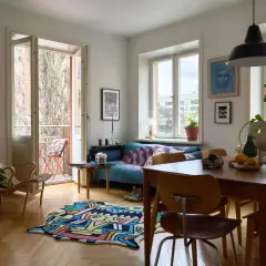 Vardagsrum med färgglad matta och soffa i ett tegelhus från 60-talet.