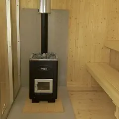 En nybyggd bastu utomhus med vedkamin och träbänkar. Perfekt för avkoppling.