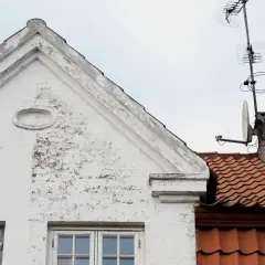 Vitt hus med tegeltak och antenner. Ett gammalt kc bruk som vittnar om svunna tider.