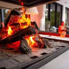 En kamin med sprakande eld. En kvinna läser en bok i bakgrunden. Perfekt för att installera kamin och njuta av värmen.