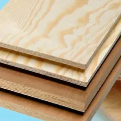 Staplade skivor av plywood utomhus, med tydliga årsringar och lager. Perfekt för byggprojekt som kräver hållbart material.