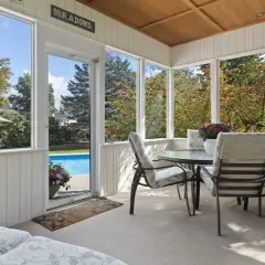 Ett mysigt uterum med matgrupp och solstol, perfekt för att bygga uterum och njuta av utsikten mot poolen och trädgården.