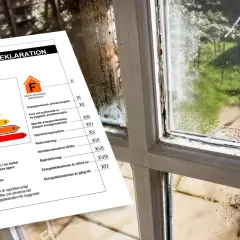 Energideklaration med klass F bredvid ett gammalt, immat fönster.
