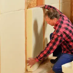 Man installerar hygroskopisk isolering i en väggkonstruktion.