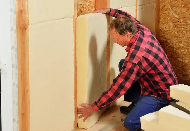 Man installerar hygroskopisk isolering i en väggkonstruktion.