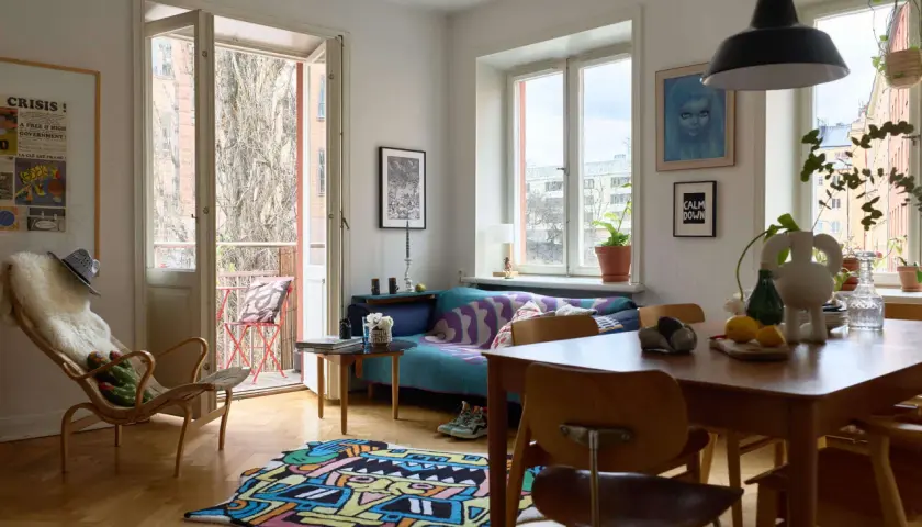 Vardagsrum med färgglad matta och soffa i ett tegelhus från 60-talet.