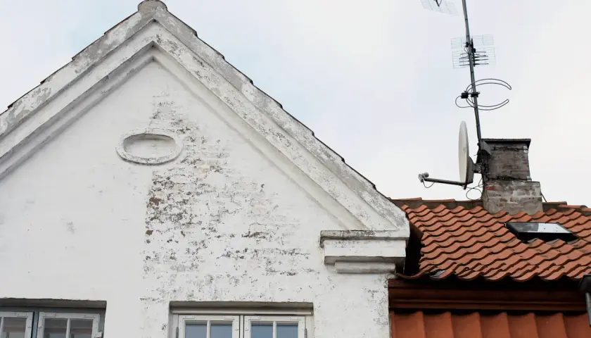 Vitt hus med tegeltak och antenner. Ett gammalt kc bruk som vittnar om svunna tider.
