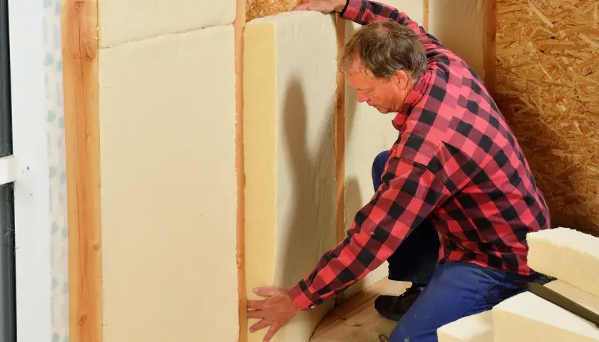 Man installerar hygroskopisk isolering i en väggkonstruktion.