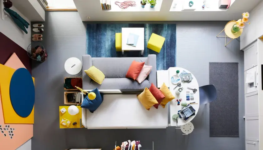 Litet tv rum inspiration med grå soffa, färgglada kuddar, blå matta och gula detaljer.