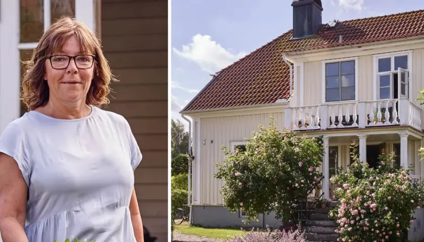 Kvinna med blommor framför ett charmigt 30-tals hus med en vacker rosenbuske.