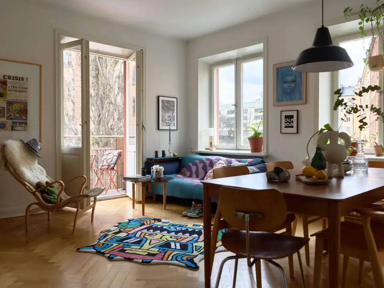 Vardagsrum i ett tegelhus fr&aring;n 60-talet med f&auml;rgglad matta, soffa och en f&aring;t&ouml;lj. Utanf&ouml;r syns en balkong.