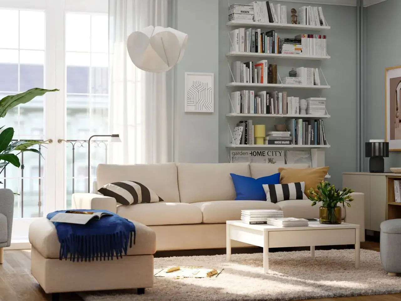 Mysigt litet tv rum inspiration med bekväm soffa, bokhyllor fyllda med böcker och en stor fönsterdörr.