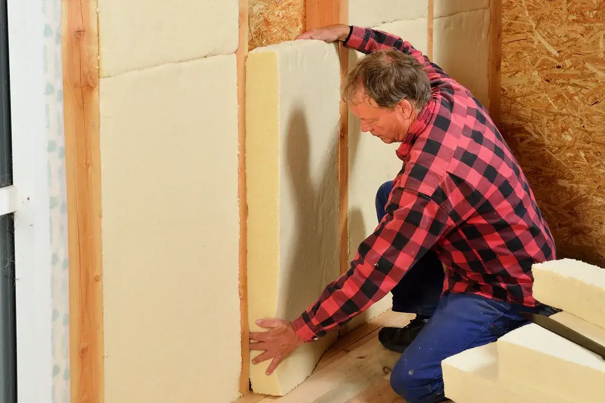 Man installerar hygroskopisk isolering i en v&auml;ggkonstruktion.