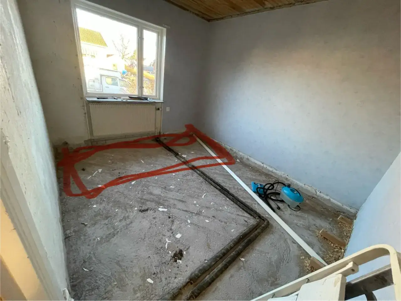 F&ouml;rberedelser f&ouml;r att isolera betongplatta i efterhand. R&ouml;rdragning och en &aring;ngmaskin syns p&aring; det dammiga golvet.