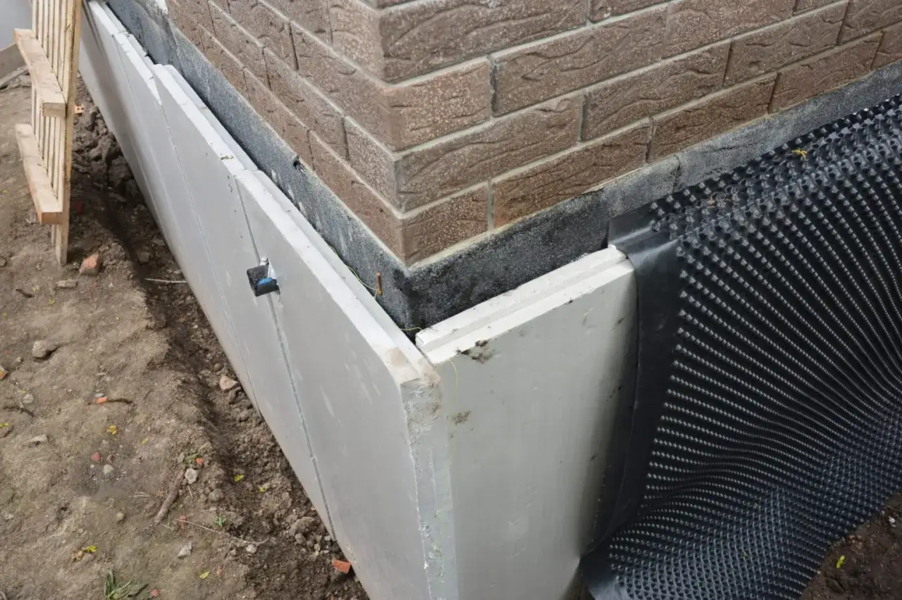 Isolering av husgrund med dr&auml;neringsmatta f&ouml;r att undvika kalla golv krypgrund.