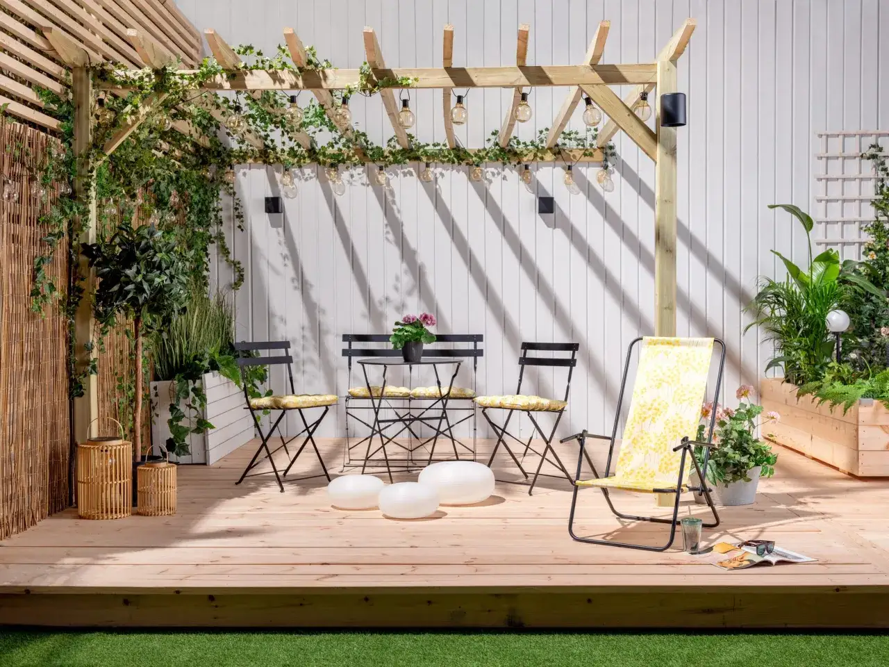 En mysig uteplats med pergola, möbler och växter. Perfekt för att bygga insynsskydd och njuta av sommaren.