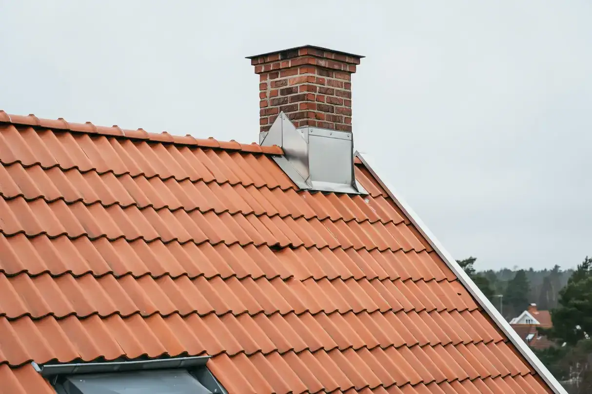 Tegeltak med en tegelpipa p&aring; ett nock hus.