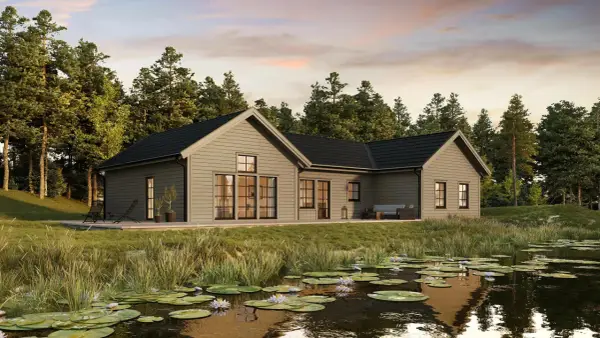 Modernt hus med brun fasad vid en näckrosdamm, omgivet av skog.